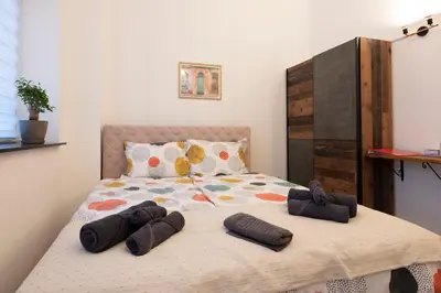 a bedroom with a bed with two pairs of slippers on it at Encanto room in Niš