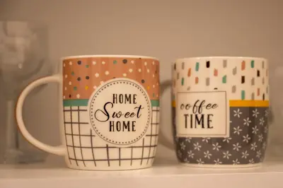 two coffee mugs with the words home sweet home on them at Encanto room in Niš