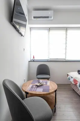 a living room with a table and two chairs at Encanto room in Niš