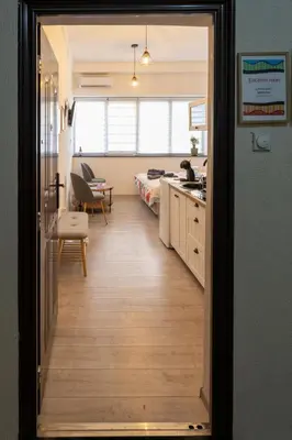 a hallway leading to a kitchen and a living room at Encanto room in Niš