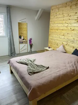 a bedroom with a large bed with a wooden headboard at Šumska vila Gašić in Kopaonik