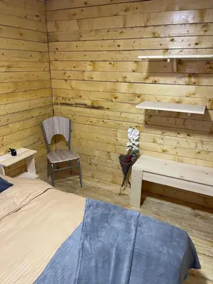 a bedroom with a bed and a chair and a table at Šumska vila Gašić in Kopaonik