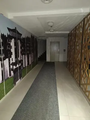 an empty hallway with a staircase and paintings on the walls at Sunčana planina apartman 104 in Kopaonik