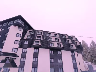a building with a black roof on top of it at Sunčana planina apartman 104 in Kopaonik