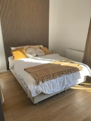 a large bed in a bedroom with a wooden floor at Apartman Lawa Kopaonik in Kopaonik