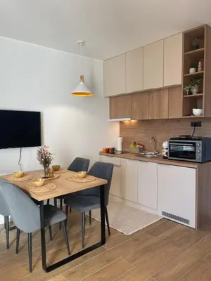 a kitchen and dining room with a table and chairs at Apartman Lawa Kopaonik in Kopaonik