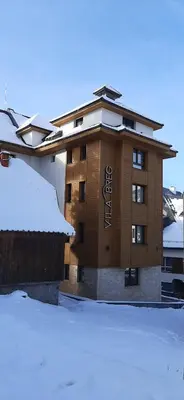 a building with a sign on it in the snow at Vila Breg Kopaonik Centar in Kopaonik