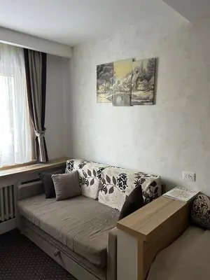 a living room with a couch and a window at KONACI Ana Apartman in Kopaonik