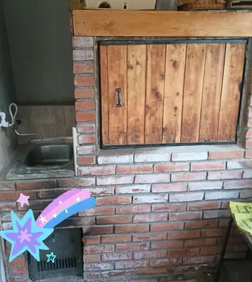a brick wall with a wooden door and a brick oven at Apartman vikend kuca Hs in Pirot