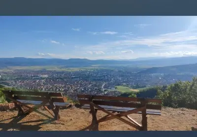 a bench sitting on top of a hill overlooking a city at Apartman vikend kuca Hs in Pirot