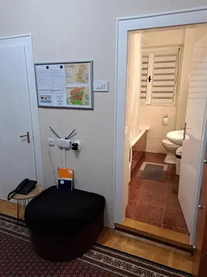 a bathroom with a toilet and a black ottoman at Apartman Dream M Zaječar in Zaječar