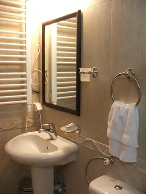 a bathroom with a sink and a mirror and a toilet at Vila Lira in Vrnjačka Banja