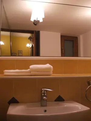 a bathroom with a sink and a mirror and towels at Vila Lira in Vrnjačka Banja