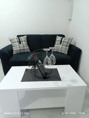 a white coffee table with two wine glasses on it at Garfield Family Apartman 2 in Soko Banja