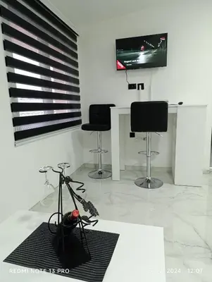 a room with three chairs and a table and a television at Garfield Family Apartman 2 in Soko Banja