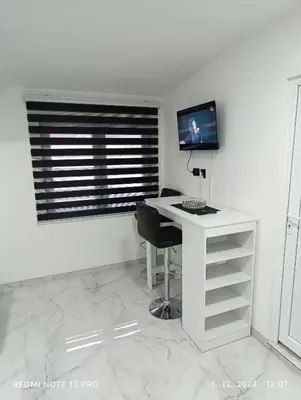 a white desk with a computer on it in a room at Garfield Family Apartman 2 in Soko Banja