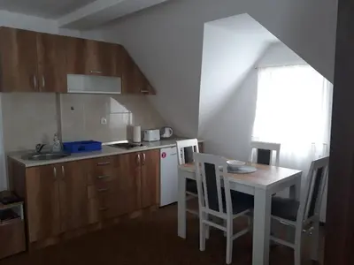 a small kitchen with a table and a white refrigerator at Dobricin Konak Kopaonik in Kopaonik