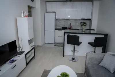 a living room with a couch and a kitchen at Apartman Jovanović in Pirot