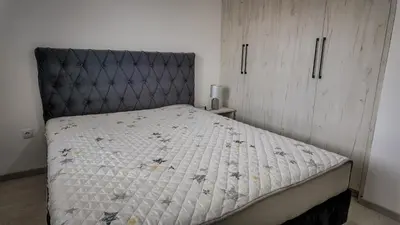 a bed with a black headboard in a bedroom at Apartman Jovanović in Pirot