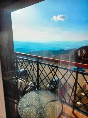 a table and chairs on a balcony with a view at Residence Hill Lux in Kopaonik
