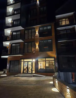 a tall building at night with its lights on at Residence Hill Lux in Kopaonik