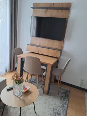 a living room with a wooden table with chairs and a television at Winter House in Kopaonik