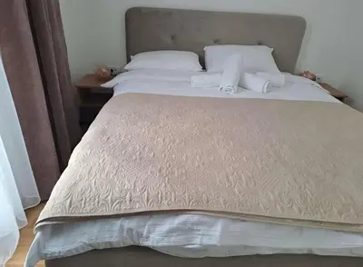 a large bed with white sheets and pillows on it at Winter House in Kopaonik