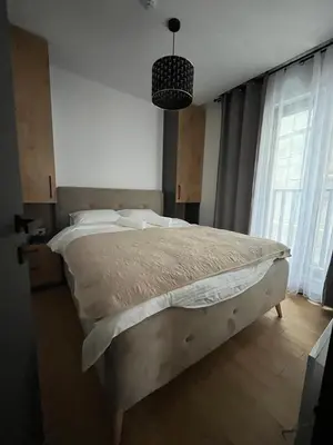 a bedroom with a large bed in a room with windows at Winter House in Kopaonik