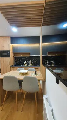 a kitchen with a wooden table and chairs at Apartmani Kasandra Wellness Spa A203 President Kop Kopaonik in Kopaonik