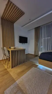 a bedroom with a bed and a desk and a television at Apartmani Kasandra Wellness Spa A203 President Kop Kopaonik in Kopaonik