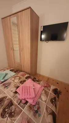 a room with a bed with pink clothes on the floor at Lily Apartmani Brzece in Brzeće