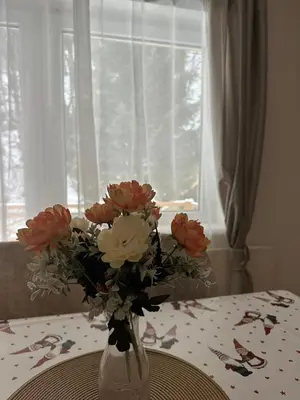 a vase filled with pink and white flowers on a table at Lily Apartmani Brzece in Brzeće