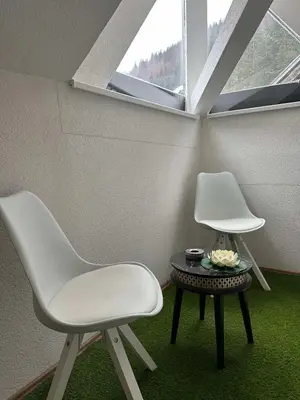 two white chairs and a table in a room with a window at Lily Apartmani Brzece in Brzeće