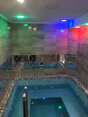 a large swimming pool in a room with colorful lights at Lily Apartmani Brzece in Brzeće