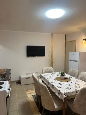 a kitchen and dining room with a table and chairs at Lily Apartmani Brzece in Brzeće