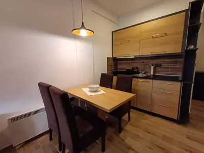 a dining room with a table and chairs and a kitchen at View N52A in Kopaonik
