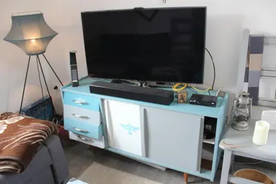 a living room with a tv on a blue entertainment center at Panorama house Goč in Goč