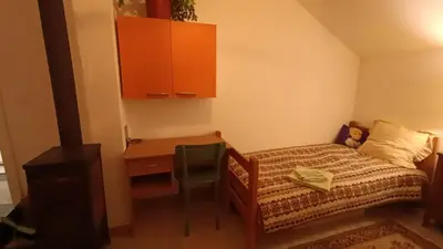 a small bedroom with a bed and a desk at Panorama house Goč in Goč