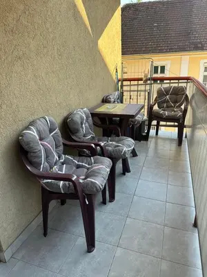 a patio with chairs and tables on a balcony at Apartman Tiki R Vrnjacka Banja in Vrnjačka Banja