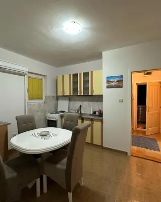a kitchen and dining room with a table and chairs at Apartman Tiki R Vrnjacka Banja in Vrnjačka Banja