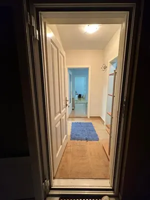 a hallway with an open door with a blue rug at Apartman Tiki R Vrnjacka Banja in Vrnjačka Banja