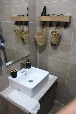a bathroom with a sink and baskets on the wall at Silvani Kop NLux67, Milmari Apartments & Spa in Kopaonik