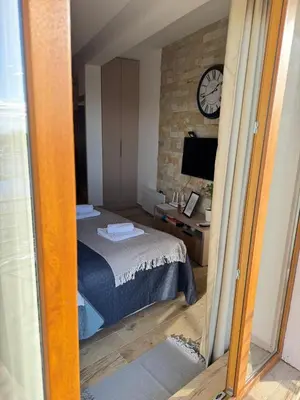a bedroom with a bed and a clock on a wall at Silvani Kop NLux67, Milmari Apartments & Spa in Kopaonik