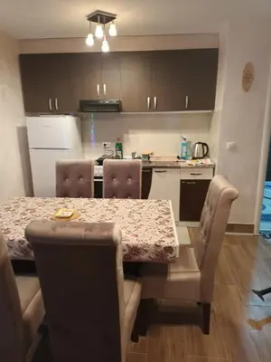 a kitchen with a table and chairs and a kitchen with a counter at Jelena Lux in Vrnjačka Banja