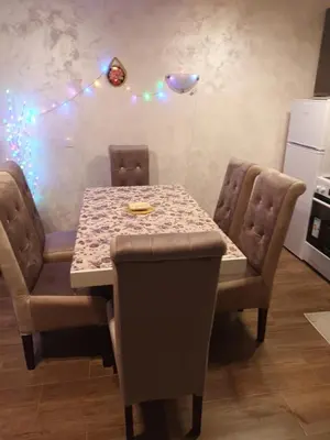 a dining room table and chairs with lights on the wall at Jelena Lux in Vrnjačka Banja