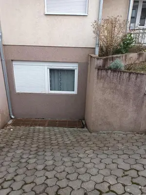 a building with a garage door and a window at Jelena Lux in Vrnjačka Banja