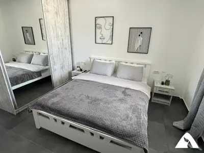 a bedroom with a bed and a large mirror at Apartman ZAM in Kopaonik