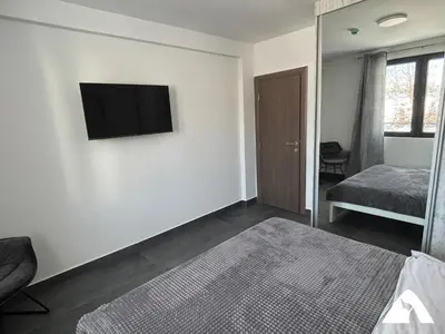 a room with a television on a wall with a bed at Apartman ZAM in Kopaonik