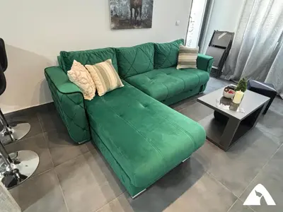 a green couch in a living room with a table at Apartman ZAM in Kopaonik