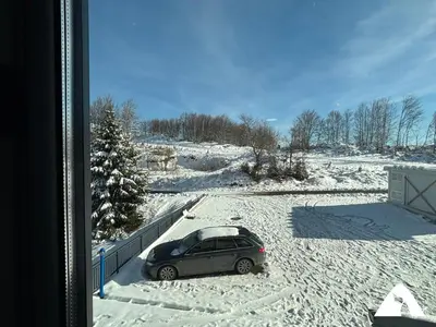 a car parked in a parking lot in the snow at Apartman ZAM in Kopaonik